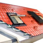 Cut-away diagram of a red metal roofing with insulation including internal and external parts, a skylight, and a solar panel.