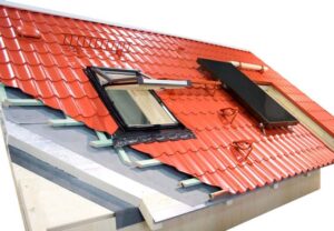 Cut-away diagram of a red metal roofing with insulation including internal and external parts, a skylight, and a solar panel.