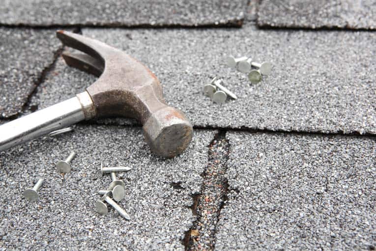 Puede clavar las esquinas dobladas con tachuelas y usar cemento para techos para sellar daños menores, pero los problemas serios requieren reemplazo.