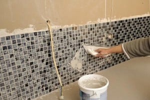 Grout is applied after the tile has been attached to the wall.