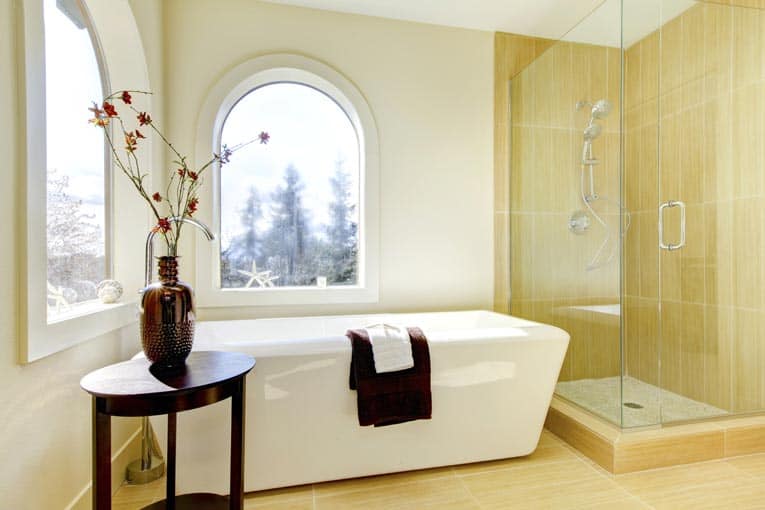 Bathroom with an enclosed glass shower area beside a freestanding tub.