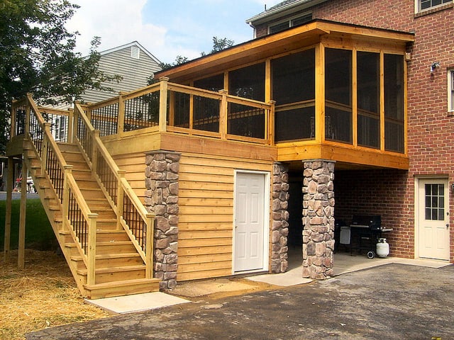 A dry storage room beneath an outdoor deck with screen porch and deck waterproofing system.