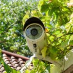 A white bullet-type, outdoor home surveillance camera.
