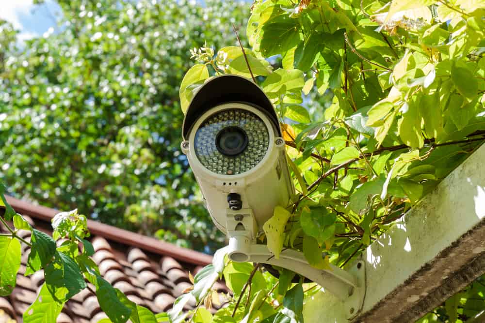 A white bullet-type, outdoor home surveillance camera.