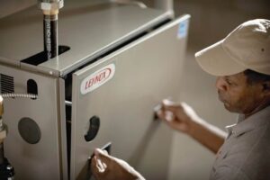 Man lifting an air-handler cabinet's door.