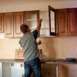 man measuring for cabinet refacing