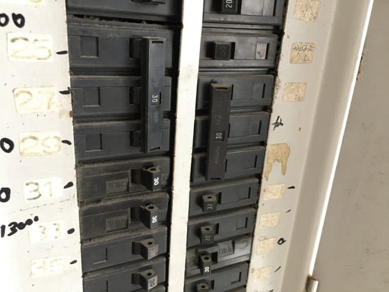 An electrical panel including black circuit breakers.