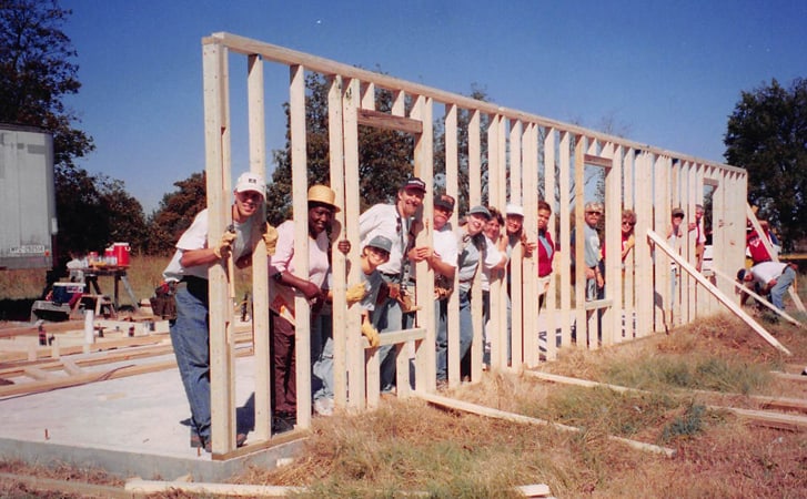 team raising new wall on a concrete slab