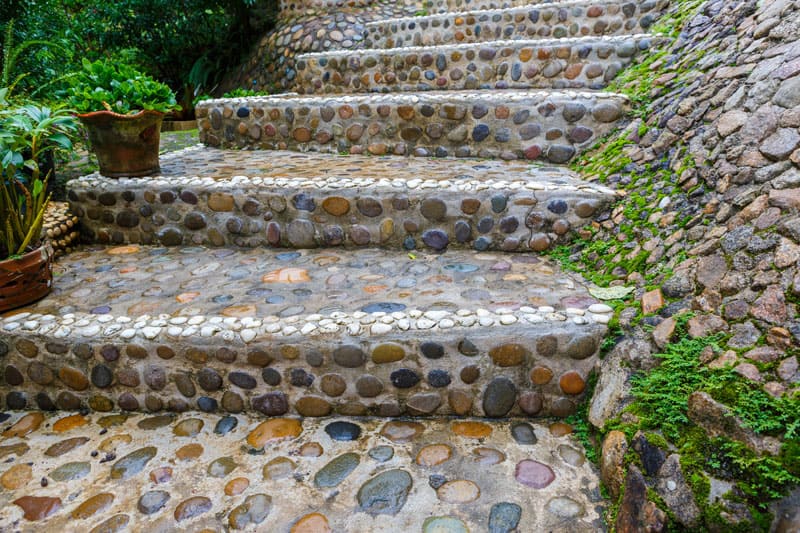 Outdoor steps made of inlaid river stones of various colors.