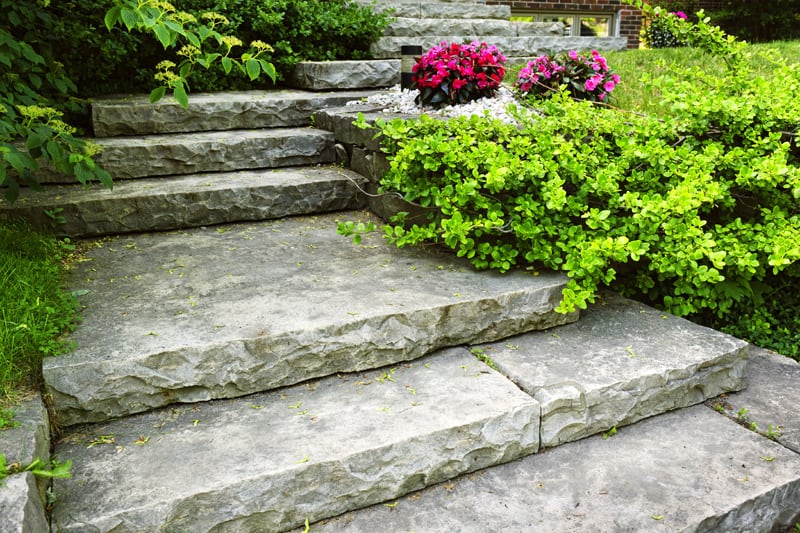 A house's front steps, made of massive, thick slabs of stone.