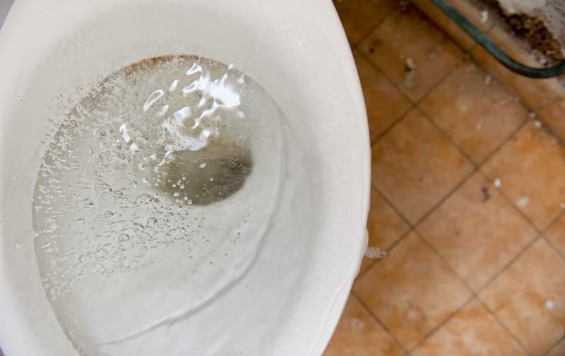 A clogged toilet filling with water