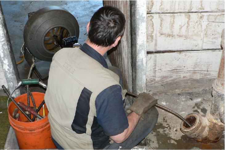 drain auger machine being pushed into drain pipe