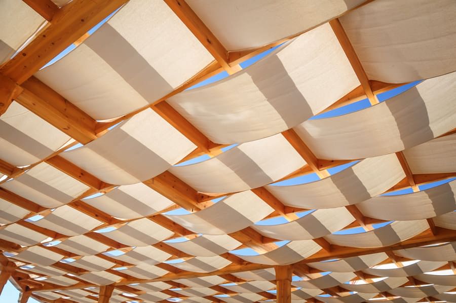 patio roof with wide fabric strips woven between the rafters