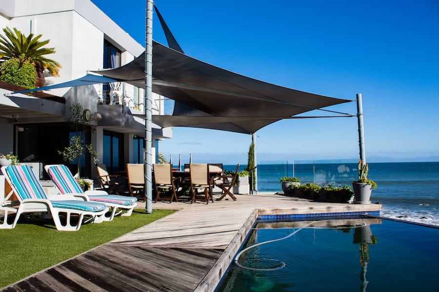 shade sail provides shelter by pool of beach home