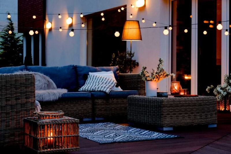 deck is lit by cafe lights and lamps