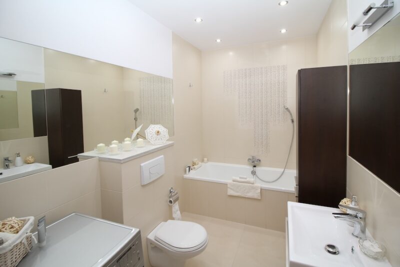 basement bathroom with mirrors, light-toned surfaces